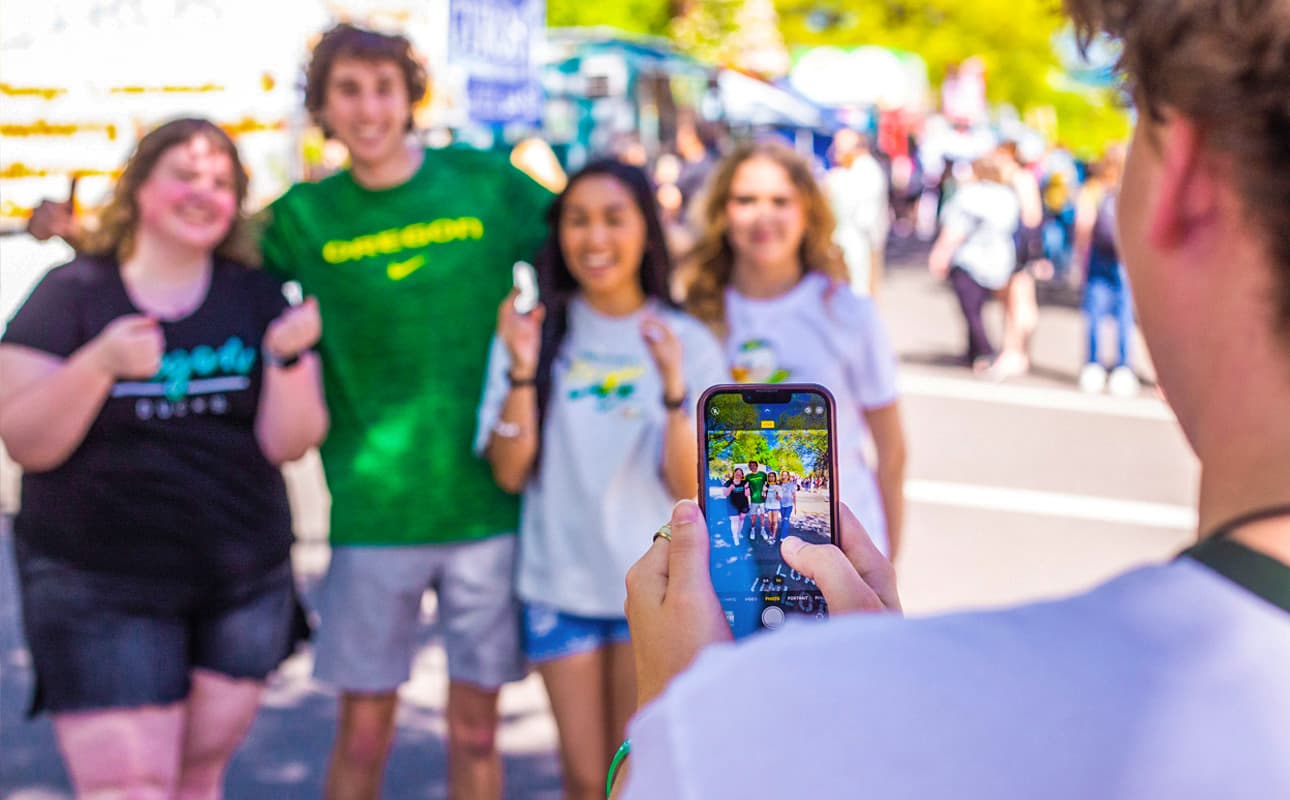 A group of University of Oregon students posing for a photo at the Street Faire.