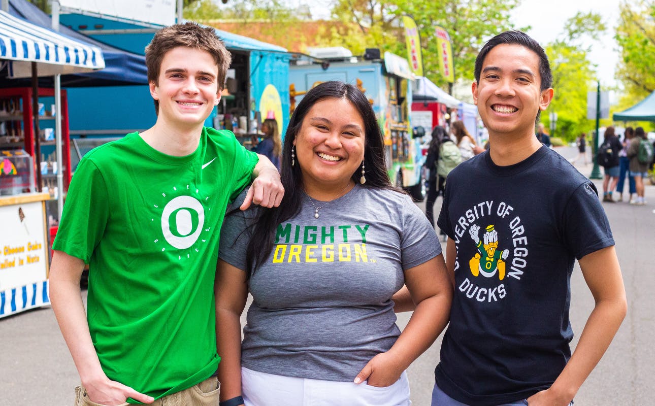 A group of University of Oregon students posing for a photo at the Street Faire.