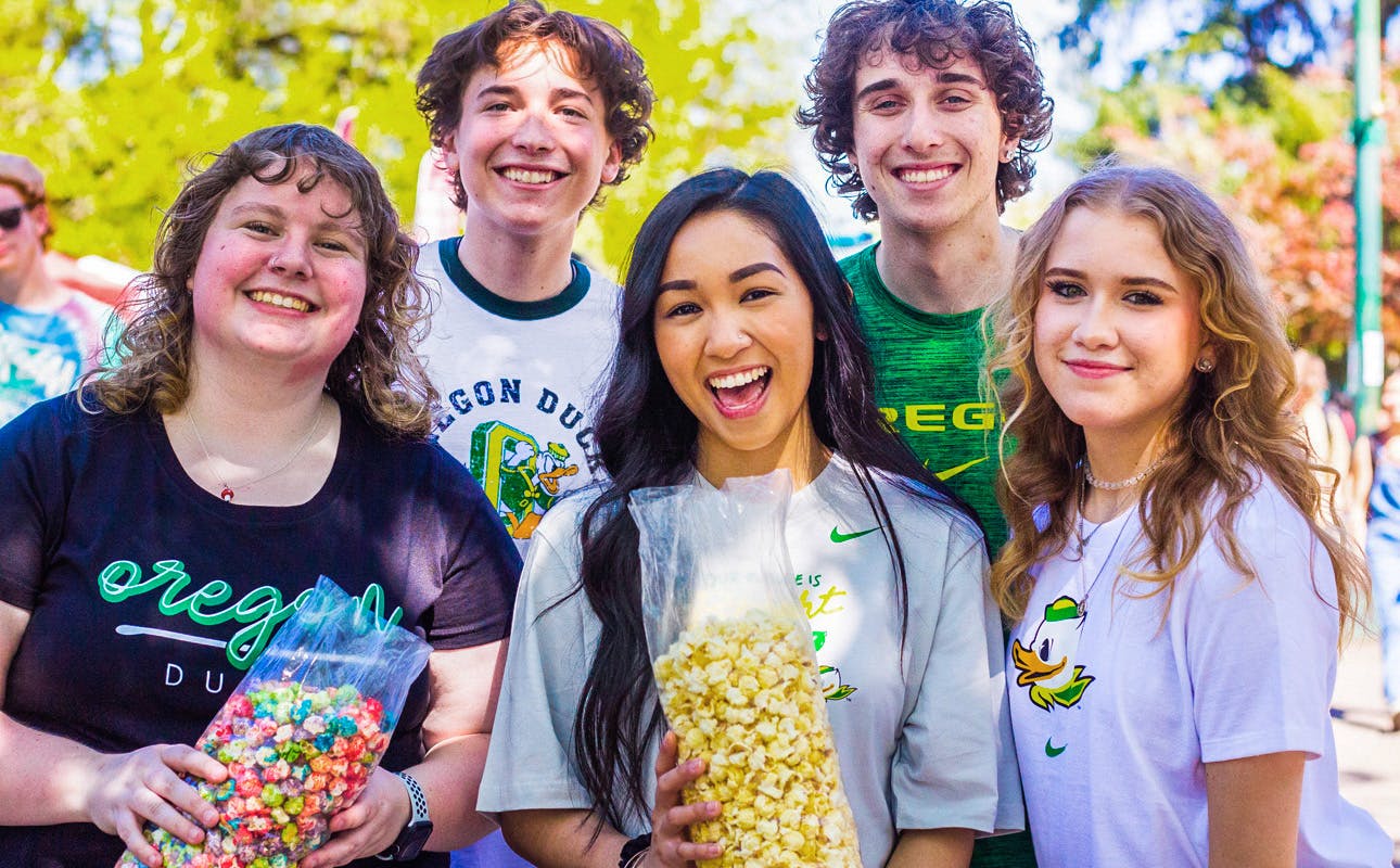 A group of University of Oregon students posing for a photo at the Street Faire.